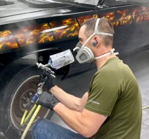 auto body paint technician at one twenty-two collision doing auto paint repair auto paint repair lobby
